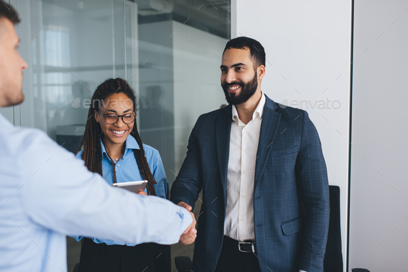 Successful Middle Eastern male boss doing handshake during work interview with professional trainee