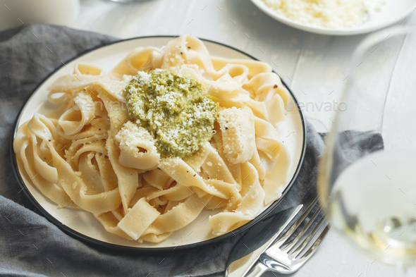 Homemade egg noodles with pesto sauce and grated parmesan cheese - Stock Photo - Images