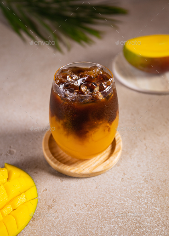 Cold mango and coffee cocktail with ice. Summer party or bar menu concept. - Stock Photo - Images