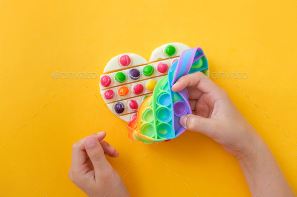 Children\'s hands take out the prepared chocolate with their own hands from the popit silicone mold.