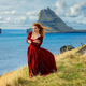 A  woman in old-fashioned clothes stands  with Tindholmur  in the background. Vagar, Faroe Islands - PhotoDune Item for Sale