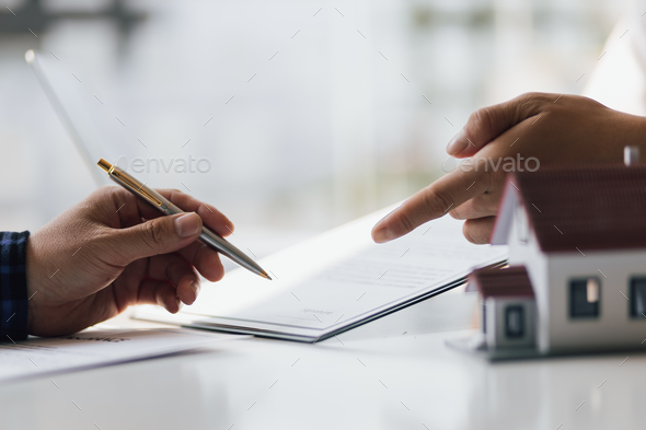 Close up businessman signing a real estate deal contract.
