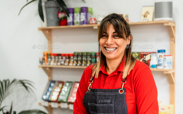 Happy Latin woman working inside supermarket - Retail food concept