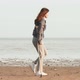 A woman on crutches walks along the beach, throws crutches and tries to walk without crutches - VideoHive Item for Sale