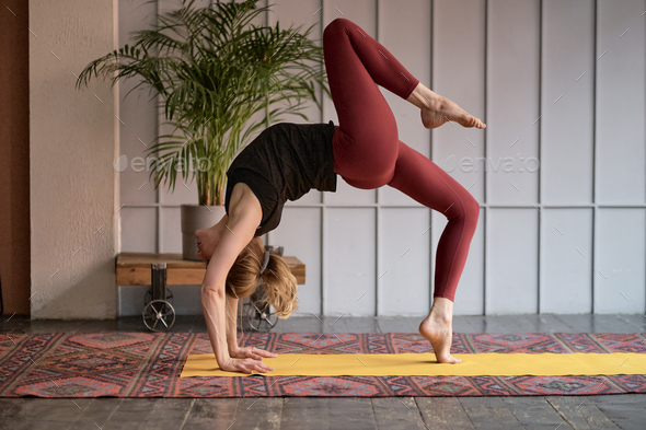 Active athletic woman practicing one leg up yoga pose Stock Photo