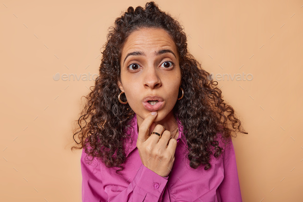 Stunned Curly Haired Woman Stares Impressed At Camera Has Mouth Opened