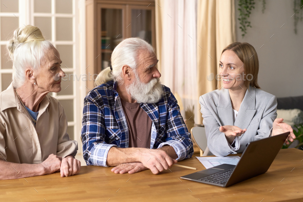 Financial consultant talking to senior couple at home