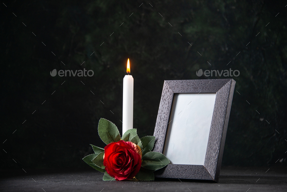 front view of burning candle with picture frame on dark surface funeral evil death war