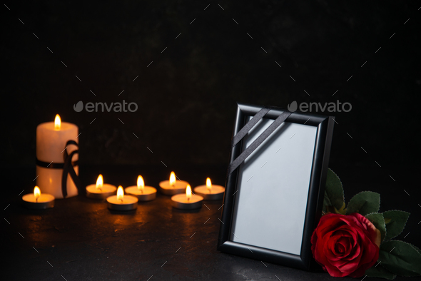 front view of burning candles with picture frame on dark surface death war evil funeral