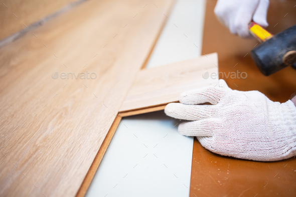Master rubber mallet knocks on the laminate in the process of laying