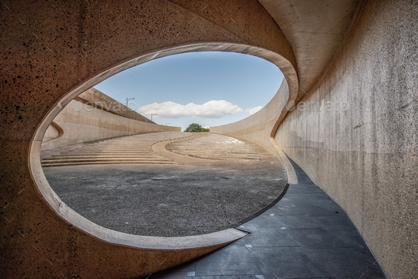 Concrete curvy arch tunnel by the highway under the cloudy sky during daytime