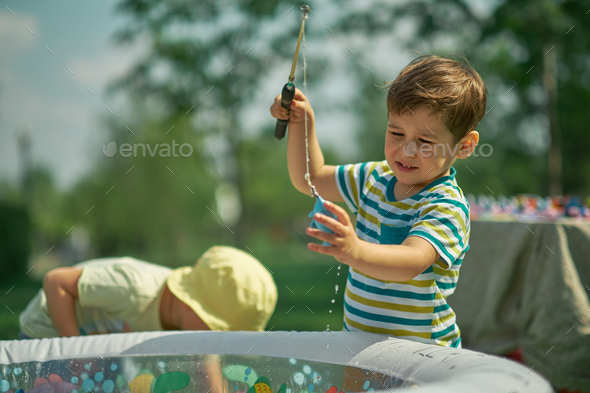 Happy Toddler boy playing in the fishing. hot summer day. children ...