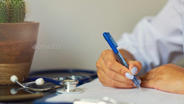 Young therapist filling medical checklist sitting at the desk. Health care and insurance concept