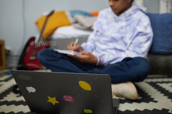 Focus on laptop cover with group of small stickers against schoolboy