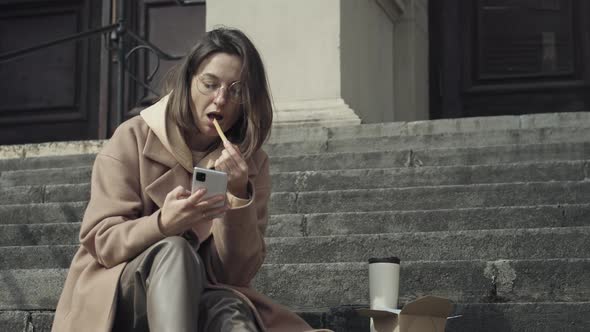 Young Adult Texting On Cell Phone And Eat alt