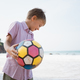 Little blond boy playing colorful ball at sea cost in summer day - PhotoDune Item for Sale