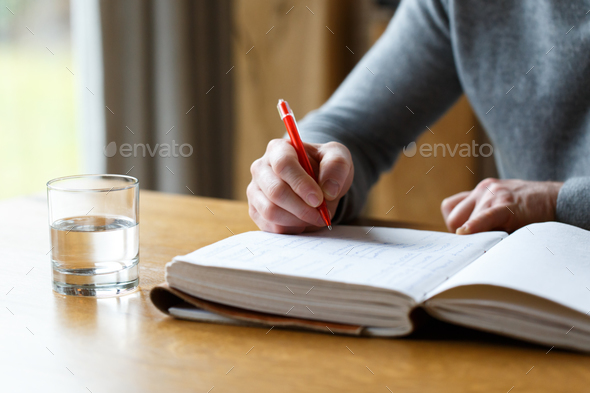 Business man in casual clothes writing with red pen - Stock Photo - Images