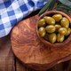 Green Mediterranean olives in a wooden bowl - PhotoDune Item for Sale