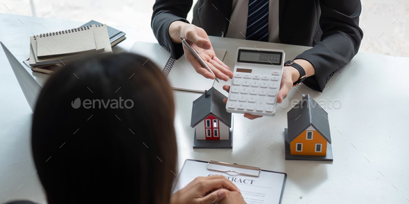Real estate agents talk to client and offer good interest rates and calculate clients on mortgage - Stock Photo - Images