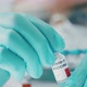 Scientist Examines a Vial with Coronavirus Vaccine - VideoHive Item for Sale