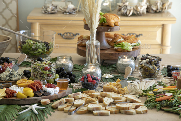 Beautiful charcuterie table set up for lunch with meats, cheeses, sandwiches, and vegetables. - Stock Photo - Images