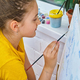 Adorable cute little girl child draws on the easel. - PhotoDune Item for Sale