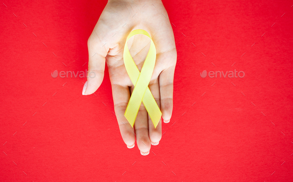 Yellow ribbon in hands, symbol Bladder cancer