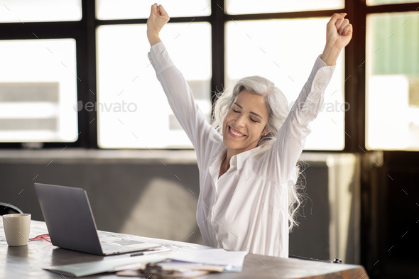 Businesswoman Shaking Fists At Laptop Celebrating Business Success In Offce
