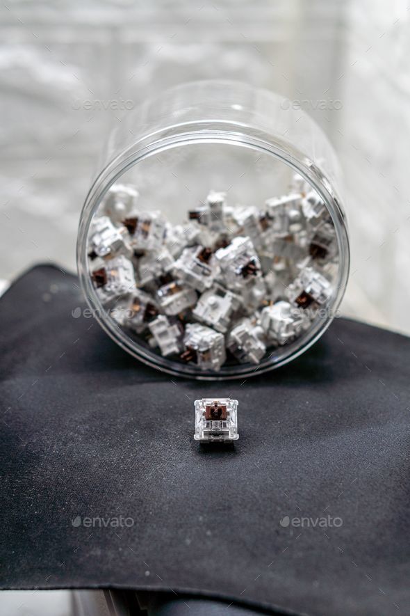 Vertical closeup of mechanical keyboard switches piled in a transparent