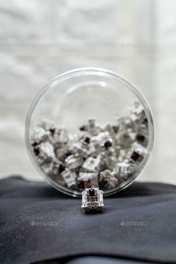 Vertical closeup of mechanical keyboard switches piled in a transparent