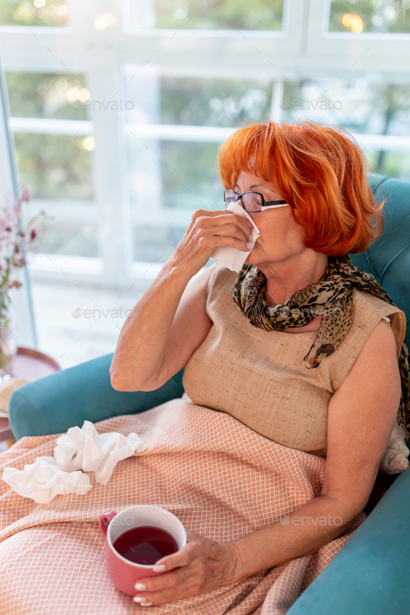 Elderly woman blowing nose