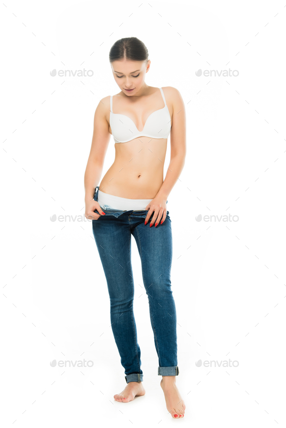 slim woman in underwear taking off blue jeans isolated on white