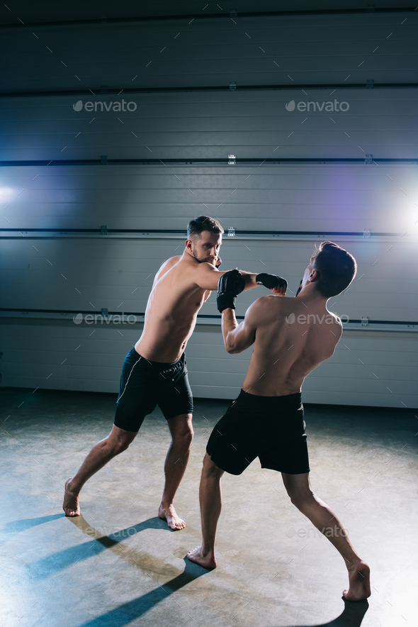 strong barefoot mma sportsmen fighting while man punching another Stock ...