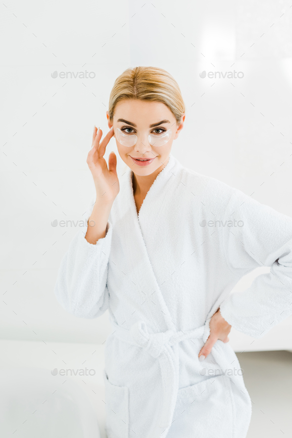 Beautiful And Blonde Woman In White Bathrobe With Eye Patches On Face