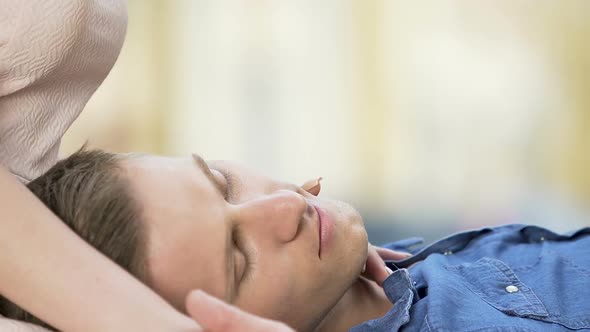Young Male Lying on Girlfriend's Laps, Female Caressing Boyfriend's Face alt