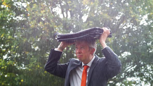 Businessman Sheltering Underneath his Bag in the Rain