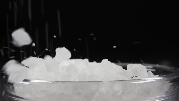 Slow Motion Large Sea Salt Falls Into a Bowl Close-up