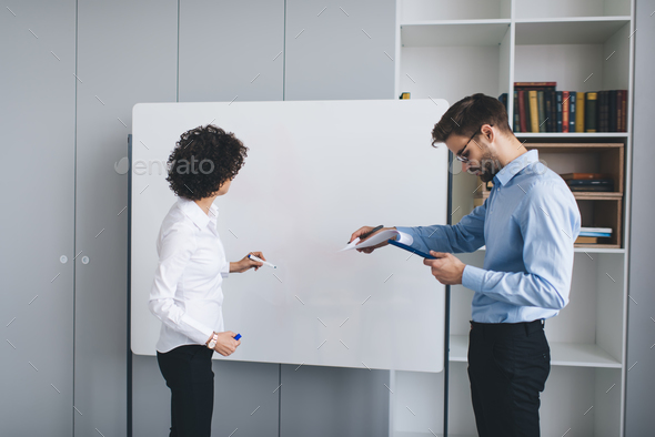 Business man and woman work at interactive board
