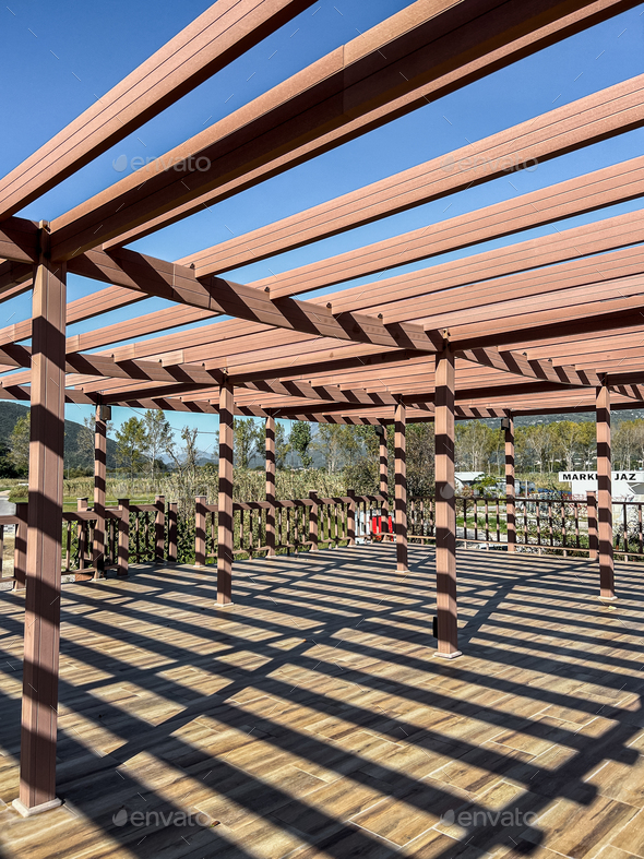 Large wooden pergola with cross beams and terrace