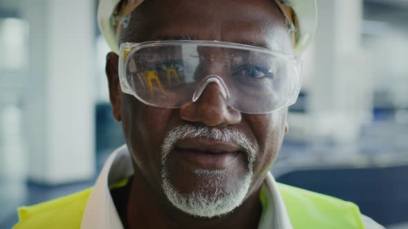Closeup Of Mature Black Construction Worker In Protective Helmet Vest And Eyeglasses alt