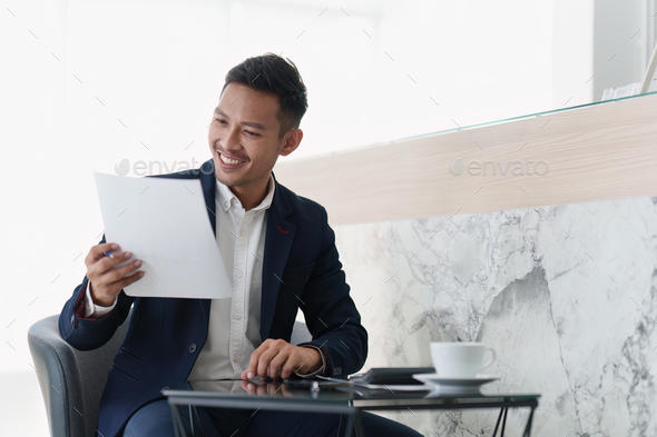 Smiling Asian Banker makes financial report and studies annual figures, analyzes profits. Accountant - Stock Photo - Images