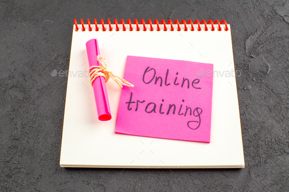 bottom view online training written on pink sticky note on notepad on black table