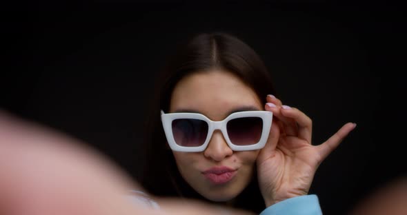 Closeup of the Face of a Brunette in Glasses Taking a Selfie on a Smartphone