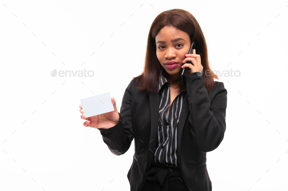 dark-skinned young smilling girl handing a card while speaking on phone isolated on white background