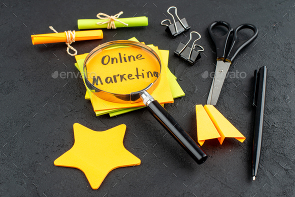 bottom view online marketing written on sticky notes star sticky notes scissors binder clips pen