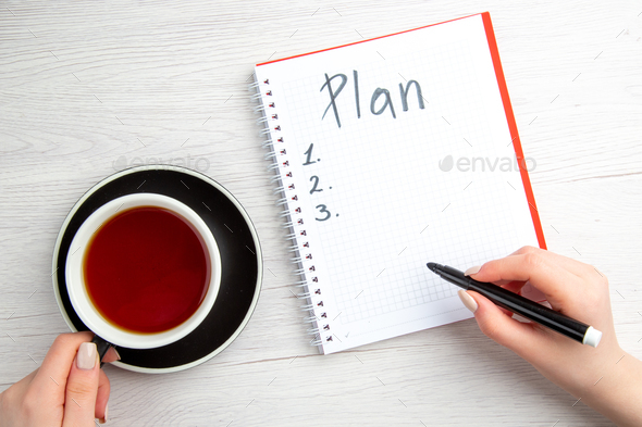 top view cup of tea with plan schedule written notepad on white background day plan sweet copybook