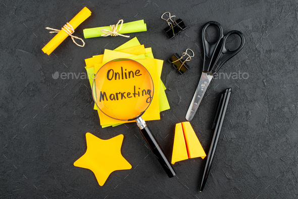 top view online marketing written on sticky notes star sticky notes scissors binder clips lupa on