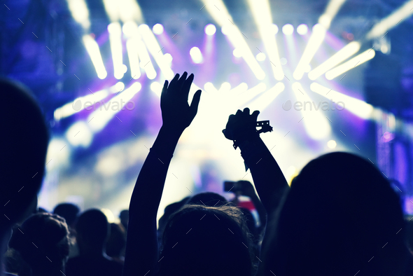 Crowd at a music concert, audience raising hands up - Stock Photo - Images