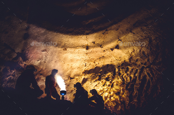 Group of speleologists resting and cooking on gas fire during a cave exploration - Stock Photo - Images