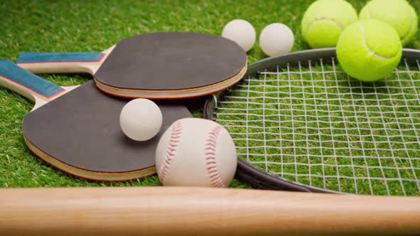 Sport Equipment Rackets and Balls on Grass Background alt